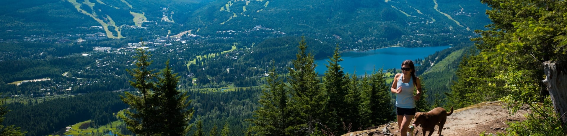 woman and her dog running in the mountains