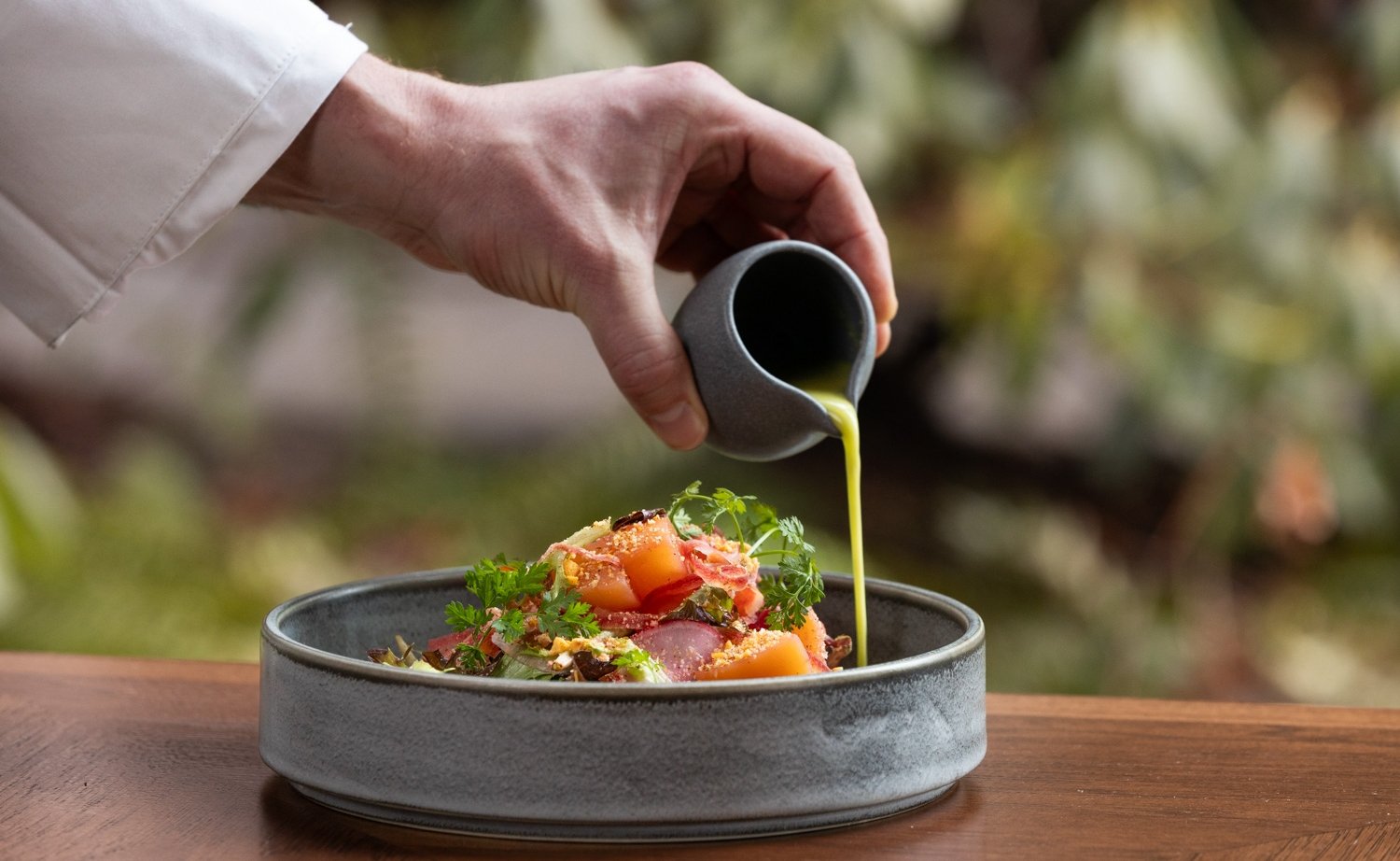 Chef pouring dressing on beetroot salad at The Wildflower Spring Dining Special