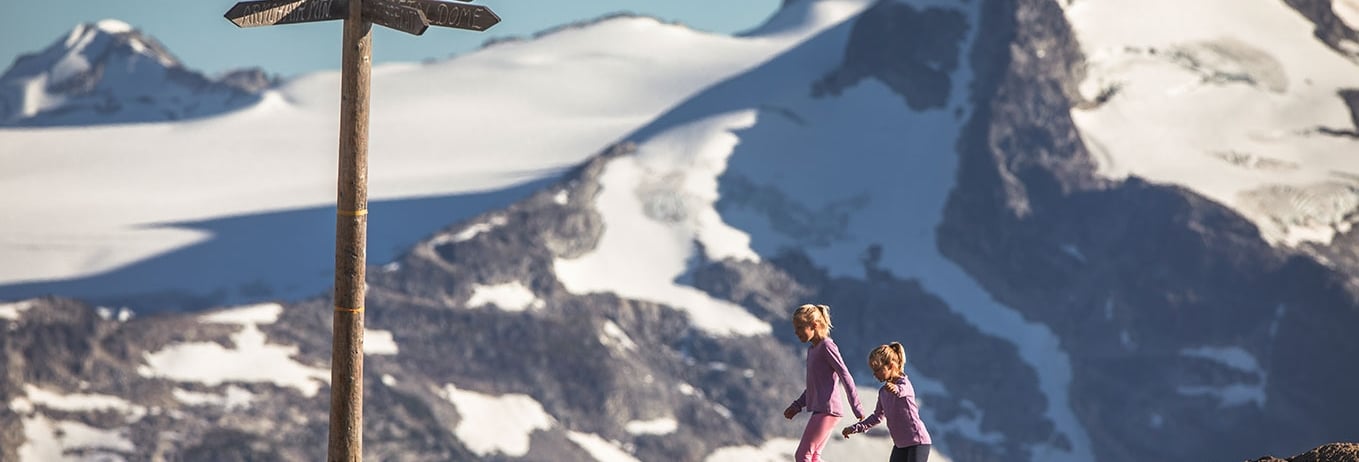 Two girls climbing on top of mountain peaks