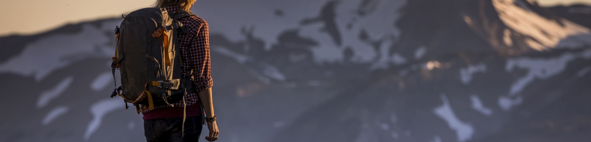 woman hiking and looking out at the mountains