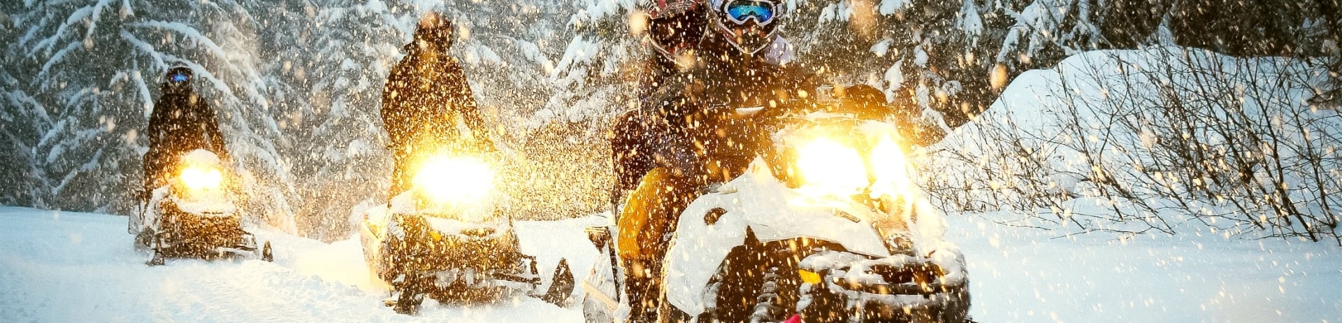 Snow mobile in blizzard through the woods and forest