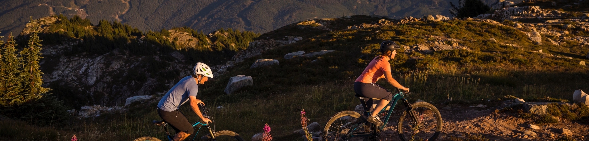 Couple with bikes enjoying ride on Sproatt mountain at sunset.