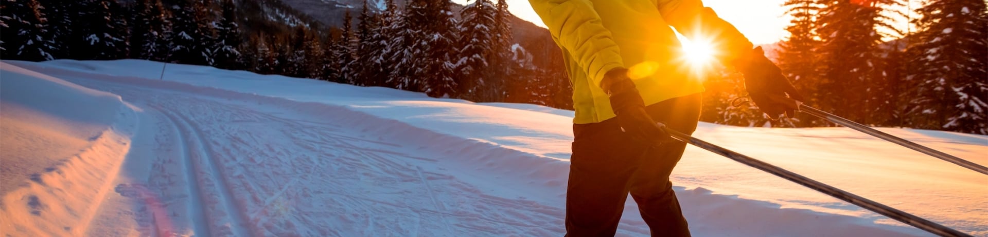woman cross country skiing at sunset in ski resort