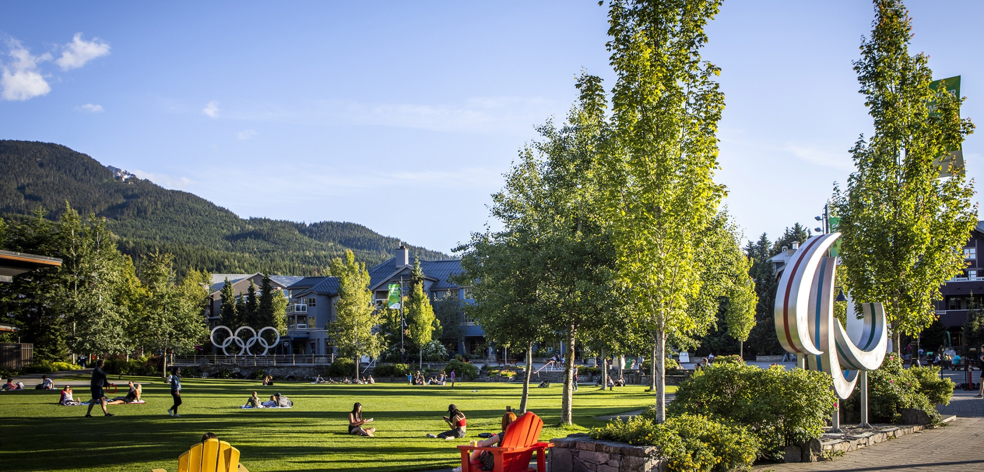 A view of Olympic Plaza in the summer time. People sit on the green and picnic.