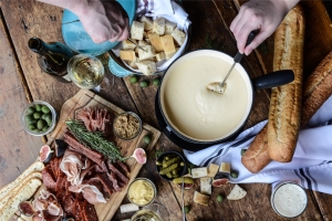 people enjoying a charcuterie board with cheese fondue
