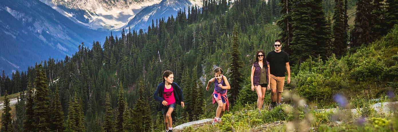 Children run ahead of their parents on an uphill hike