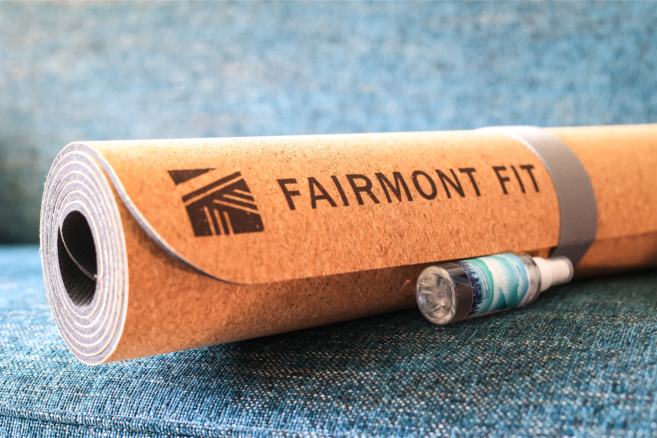 rolled up yoga mat with a bottle of mat cleaner