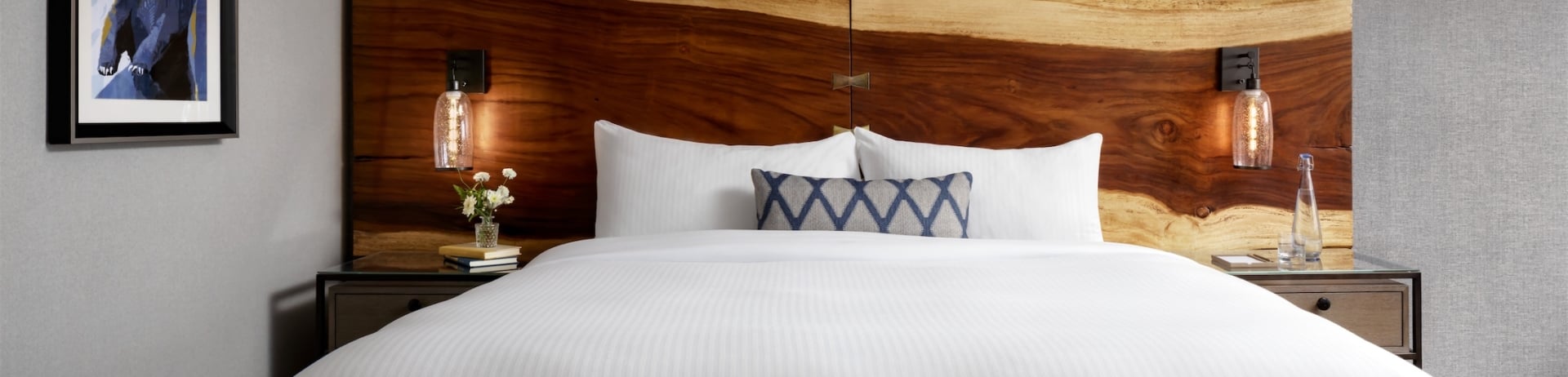 bedroom with wooden headboard and geometric bear wall art