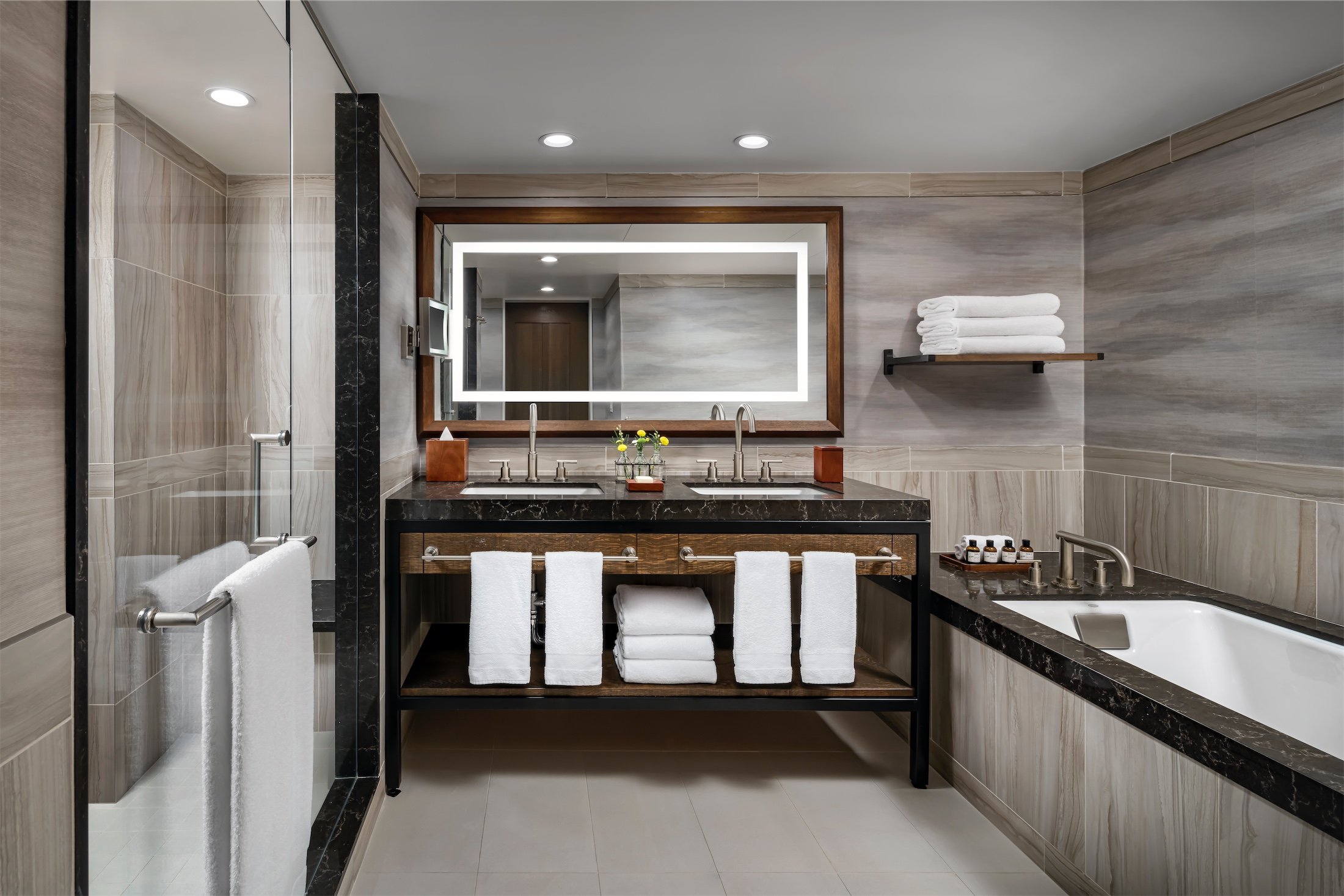 large bathroom with a tub, walk-in shower, and twin sinks