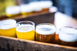 close up view of the top of a row of beers on a wooden tray