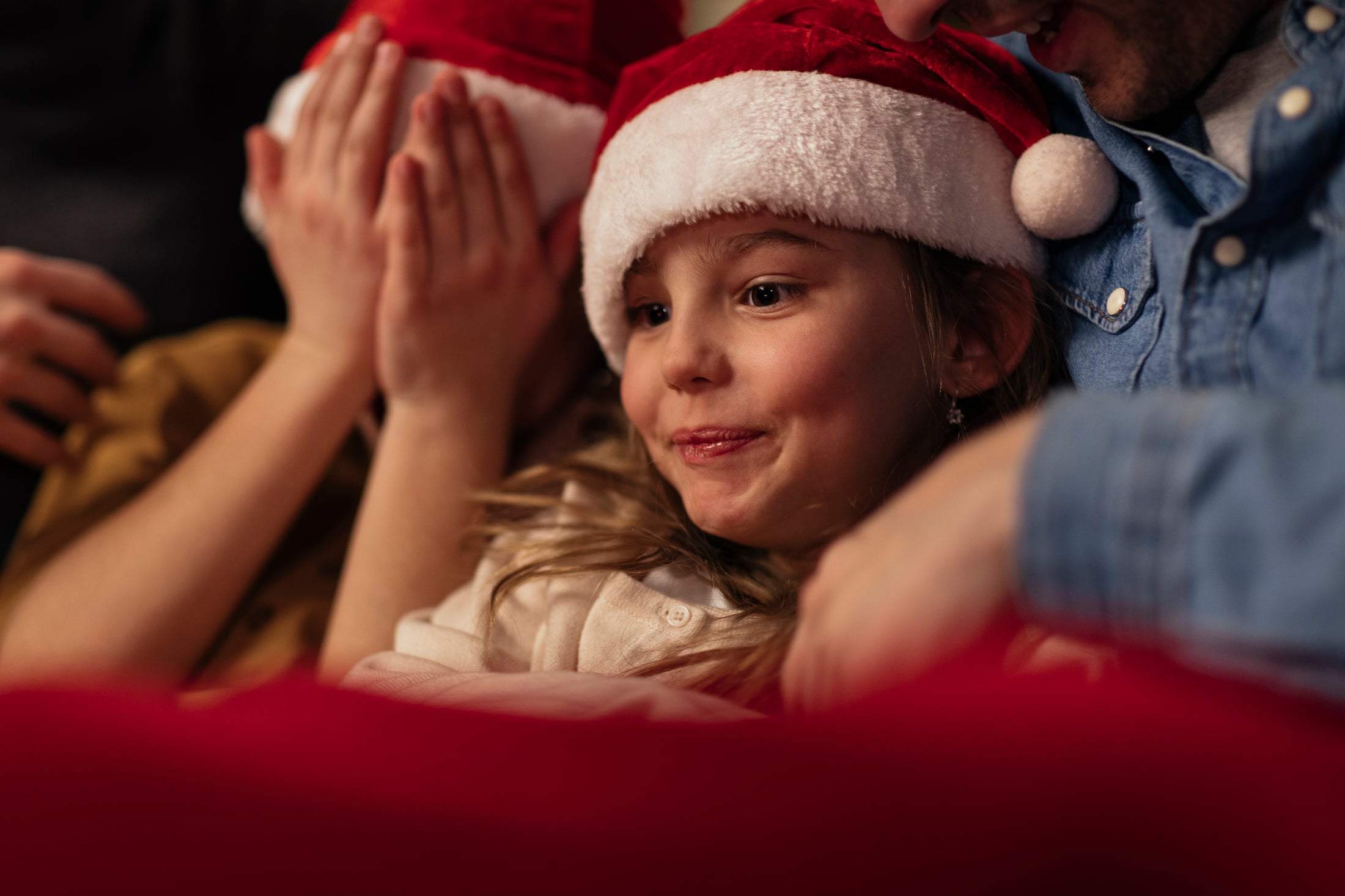 Family watching the movie together with Santa hats