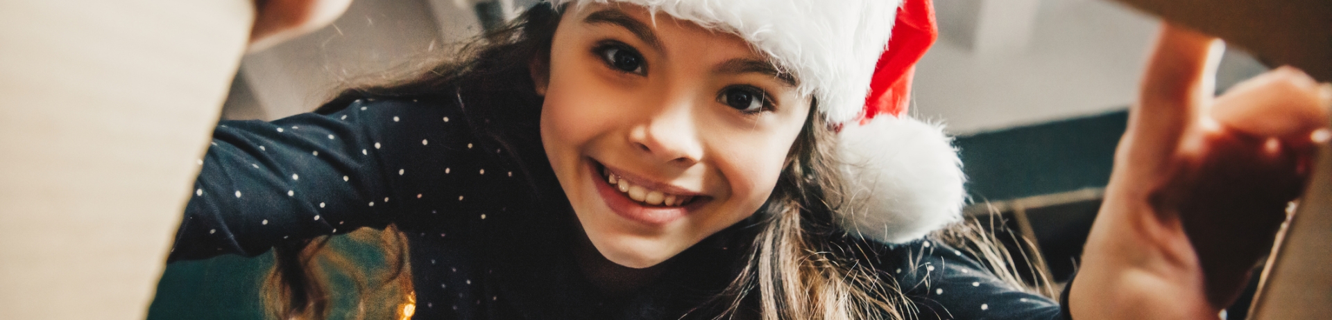 Surprised cute child girl opening a Christmas present