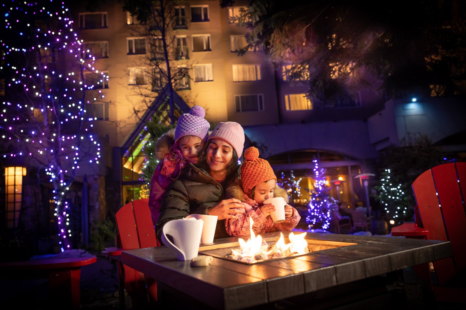 Hot chocolate by the fire mom and two kids having a cookie and hot chocolate festive celebrations at fairmont chateau whistler