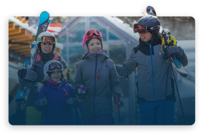 A family in ski gear outside a resort hotel