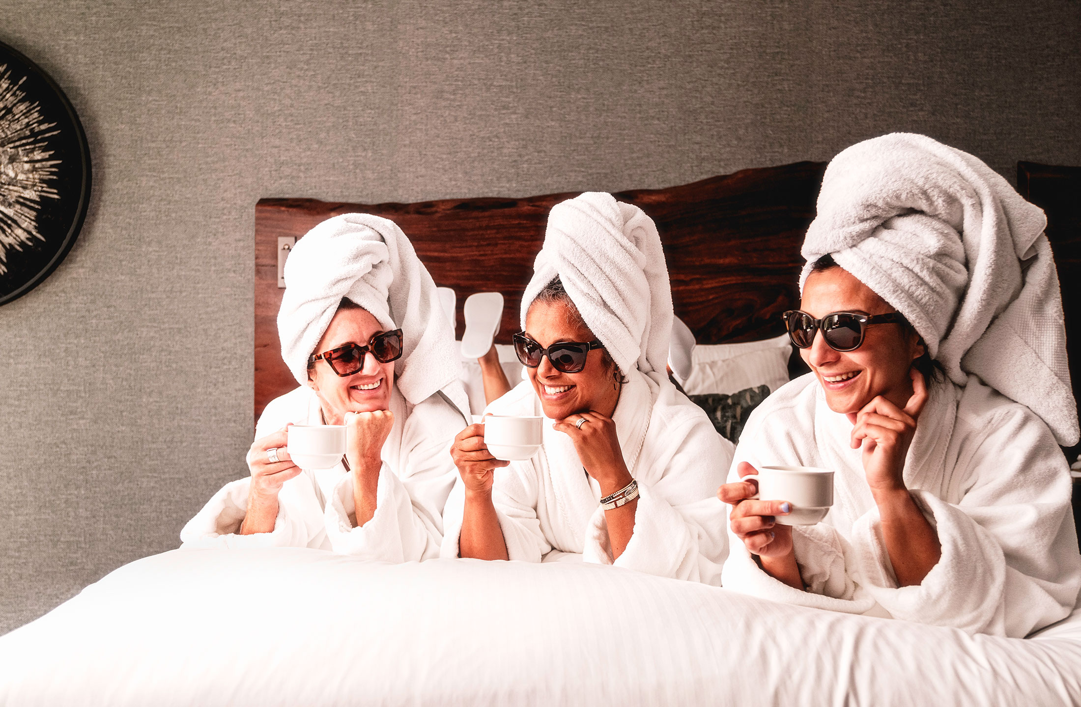 Women friends enjoying coffee in bed at Fairmont Chateau Whistler