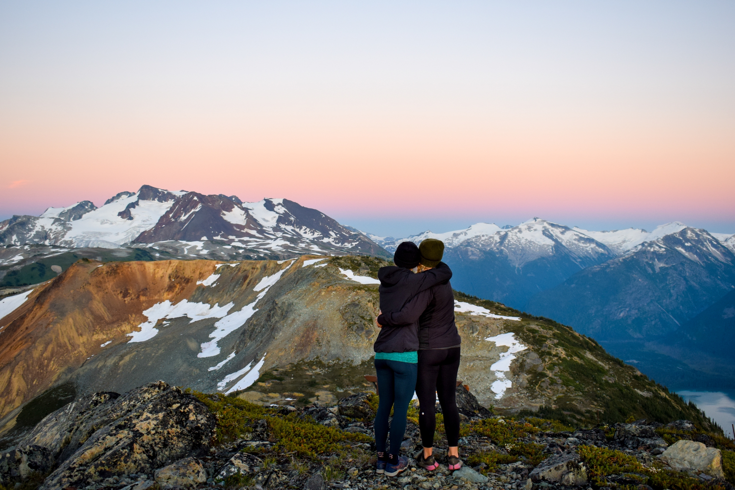 Friends hugging on a Whistler mountain top