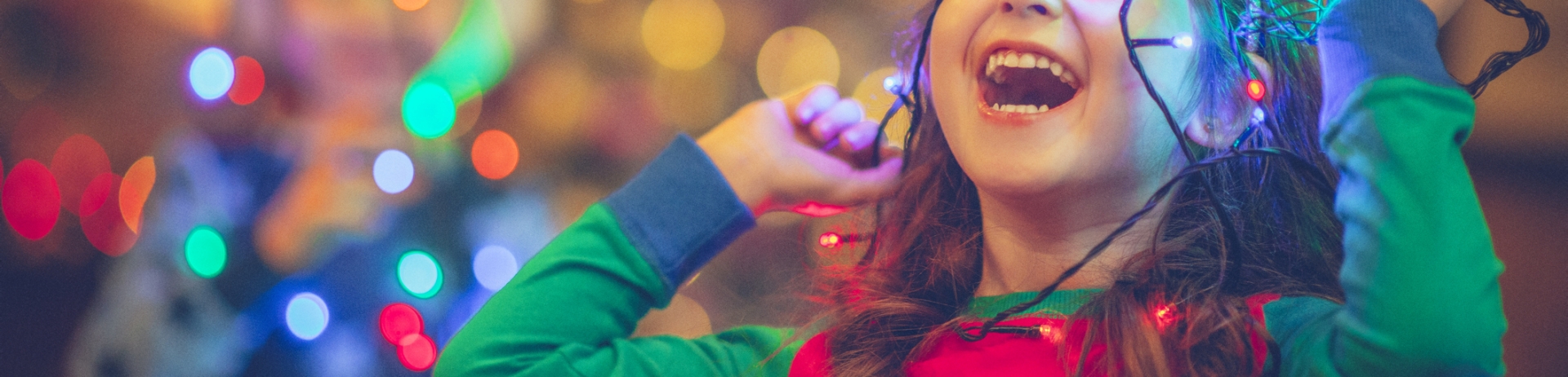 Little girl and boy in Christmas playing with lights