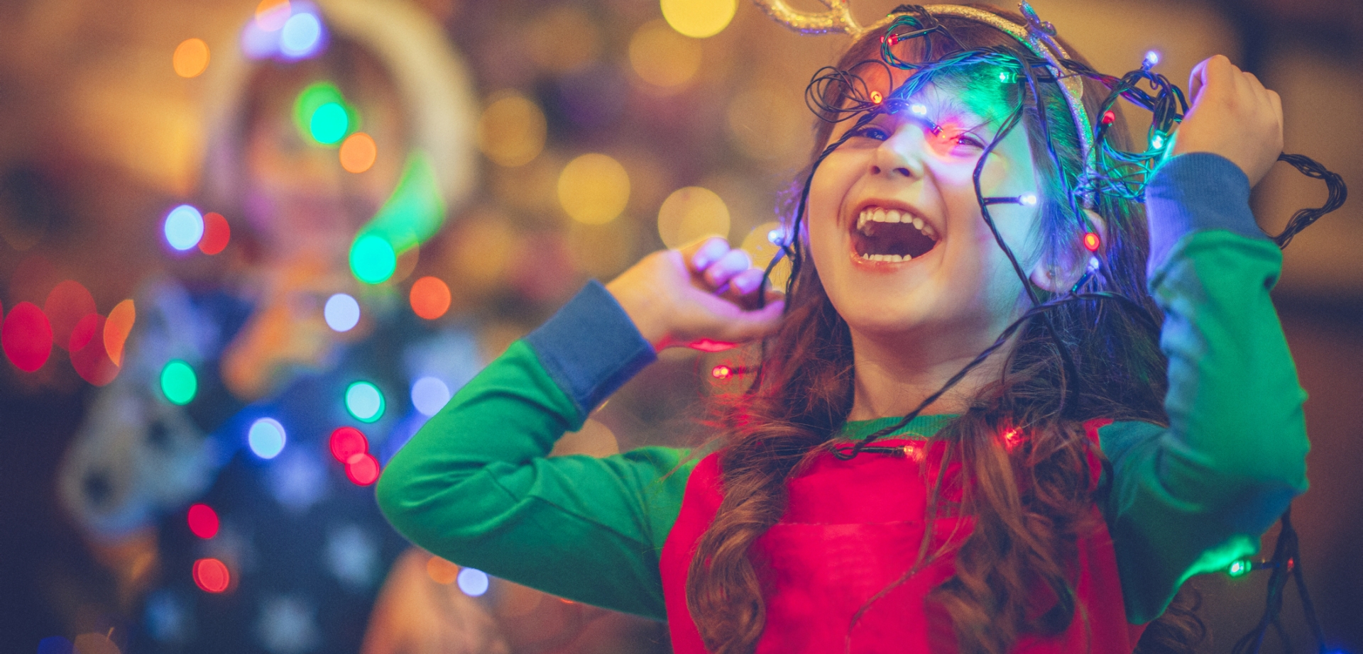 Little girl and boy in Christmas playing with lights