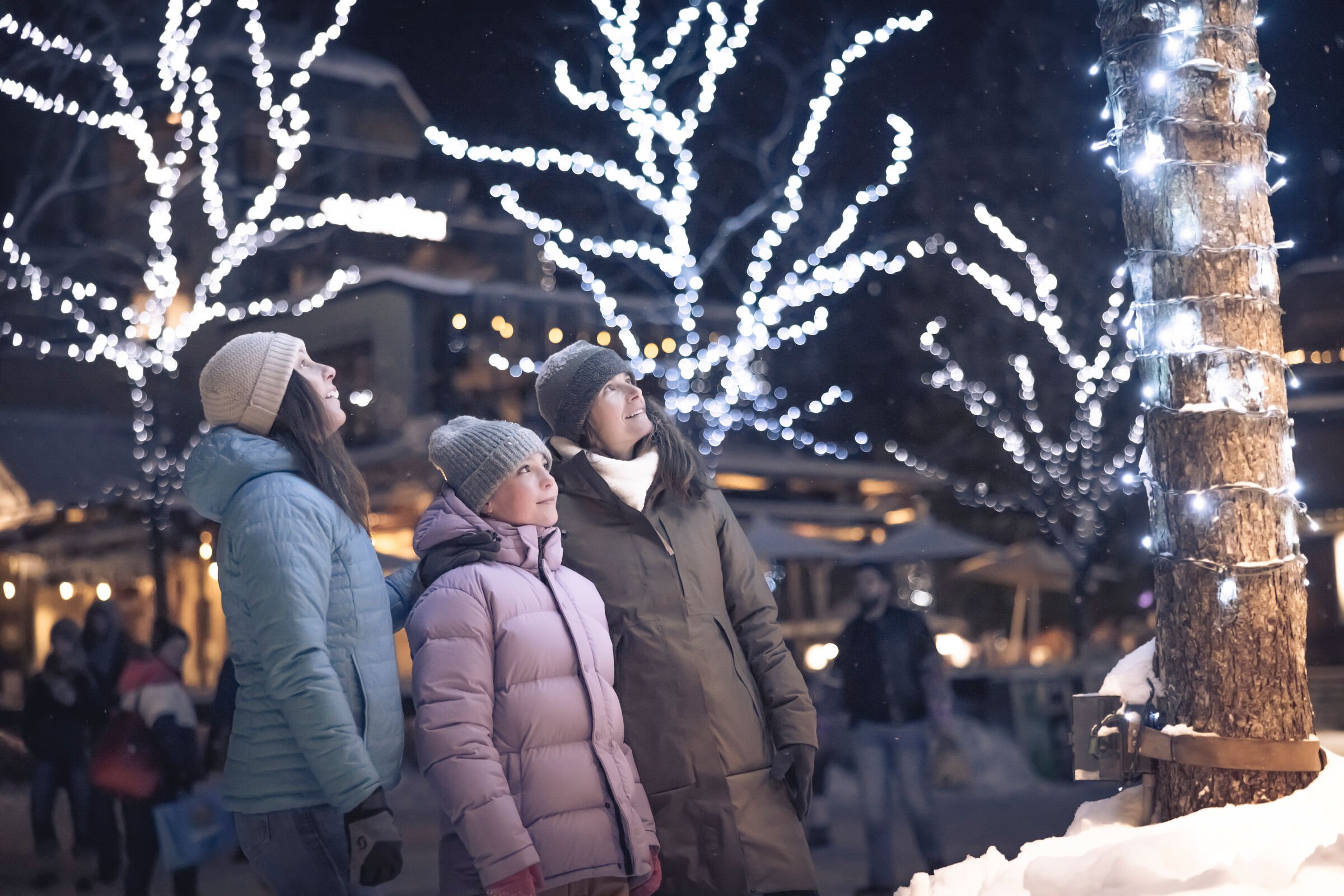 Family enjoying the Village Stroll in Whistler, British Columbia on a snowy winter evening