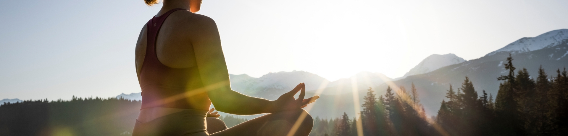 Woman doing yoga on a dock in the morning sun in Whistler