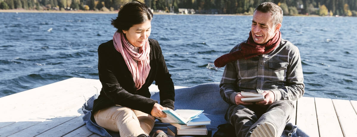 couple reading books on a dock