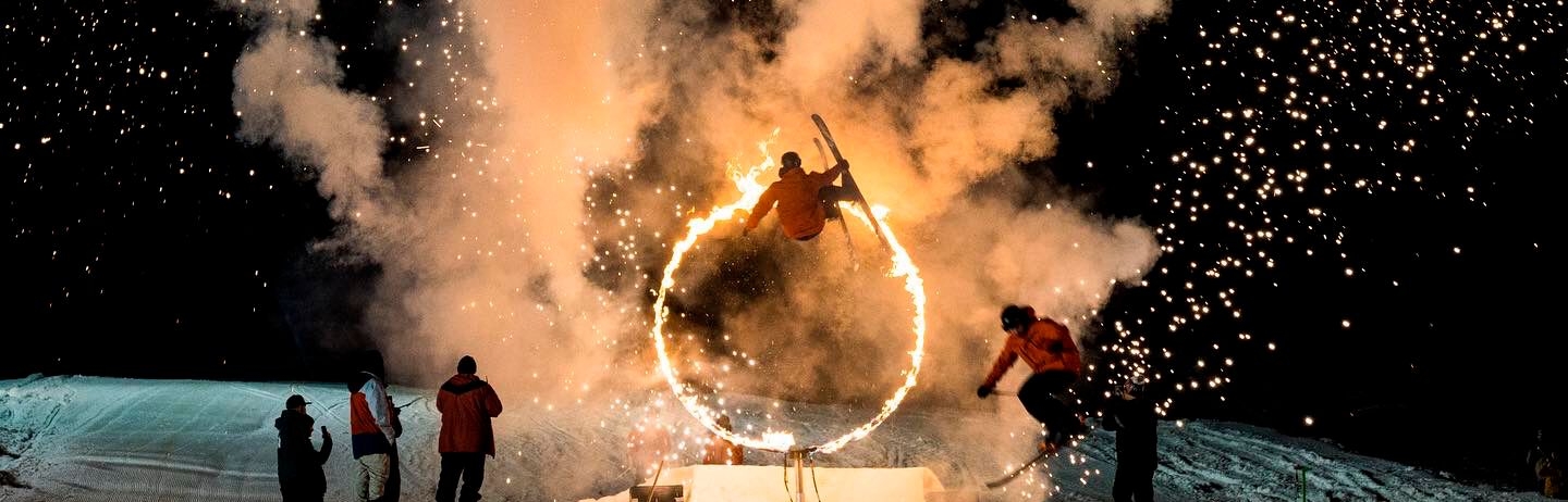 man skiing through a fire hoop fire and ice event whistler