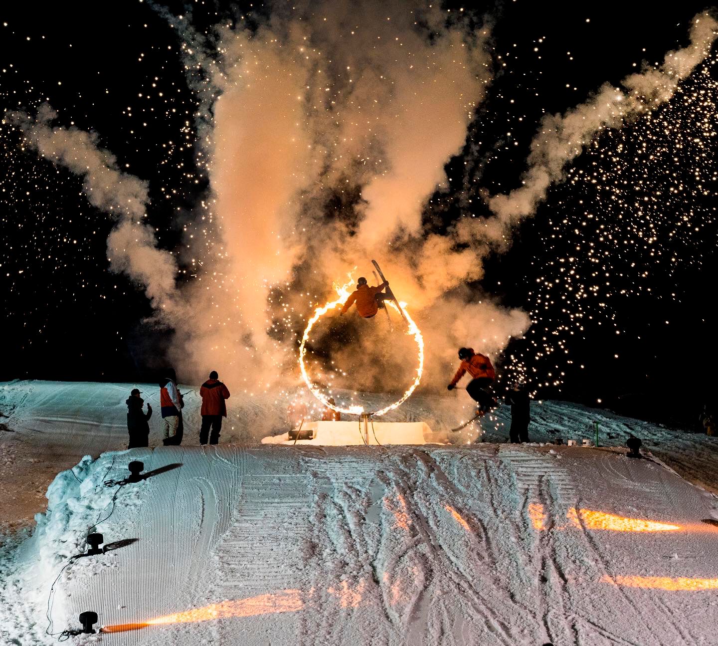 man skiing through a fire hoop fire and ice event whistler