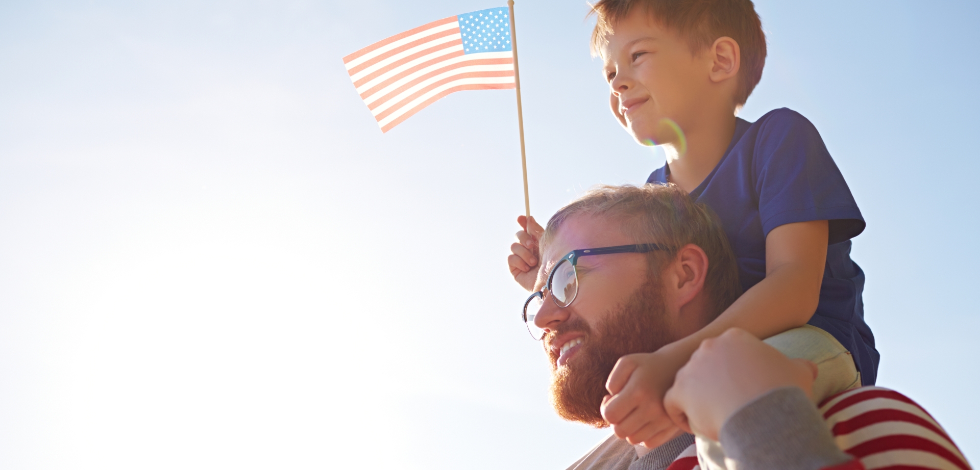 Patriotic family with American flag visiting parade devoted to Independence Day