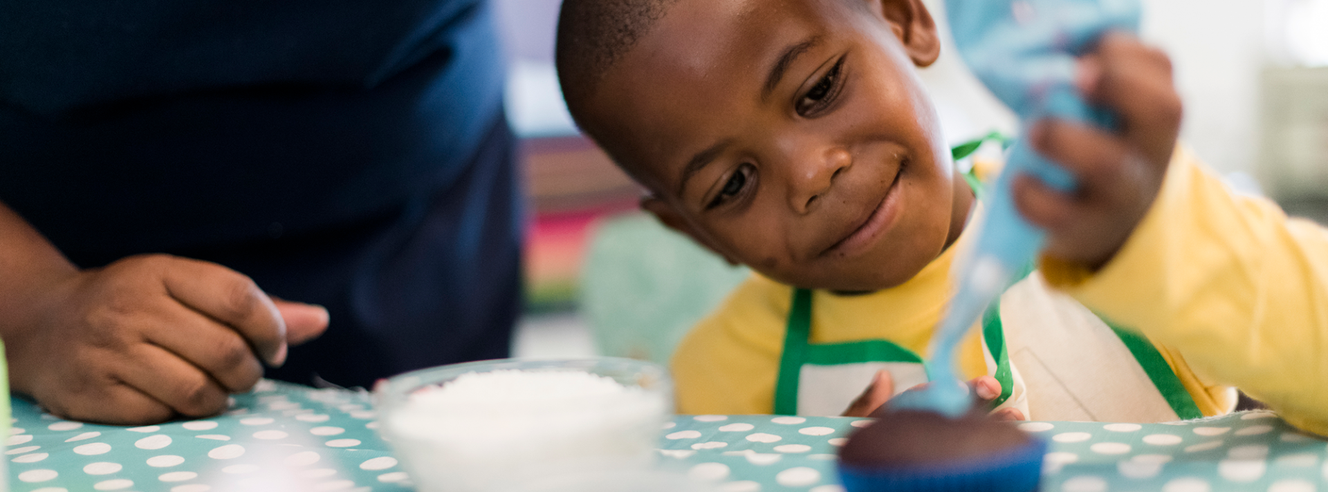 kid decorating cupcake