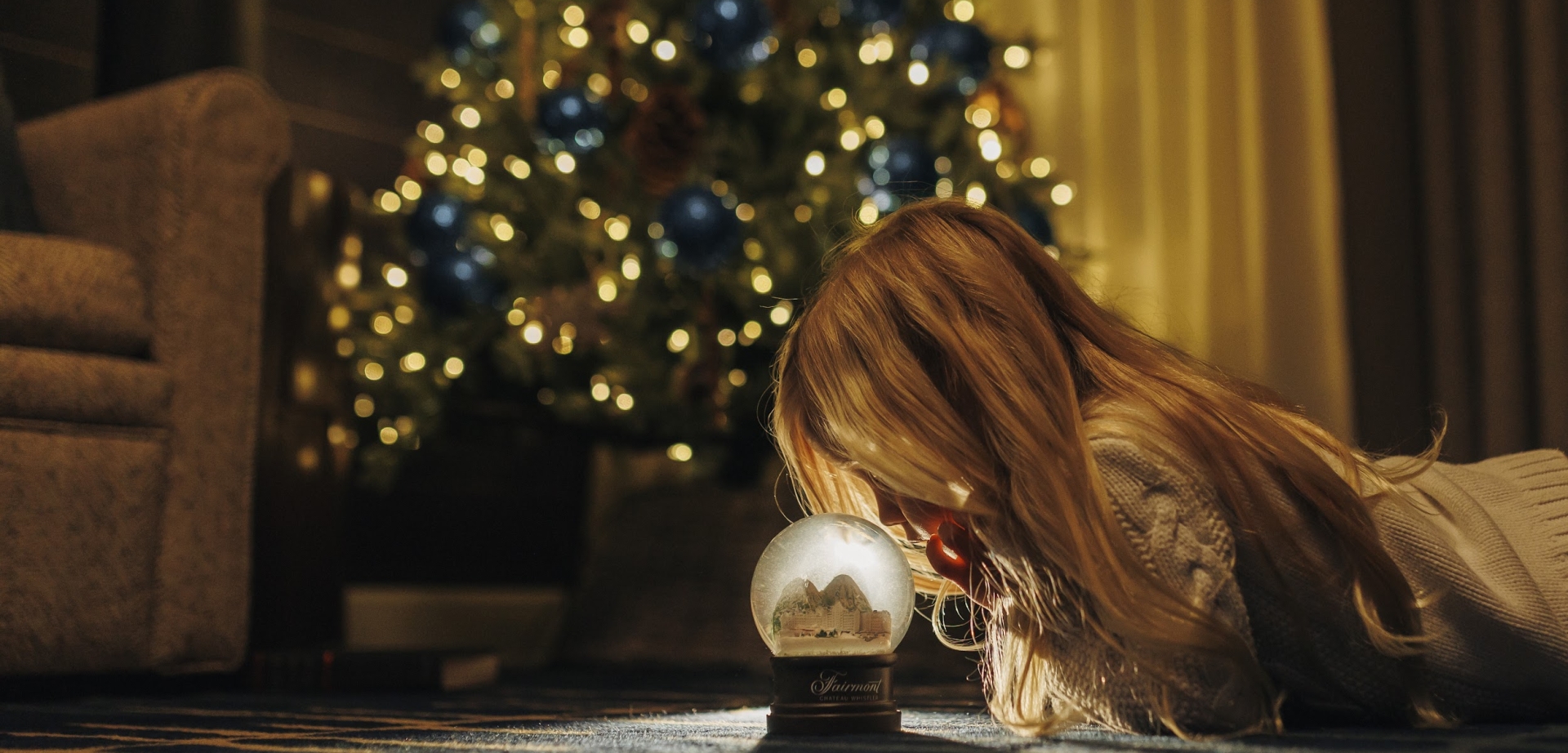 little girl starring at snow globe at fairmont chateau whistler suite