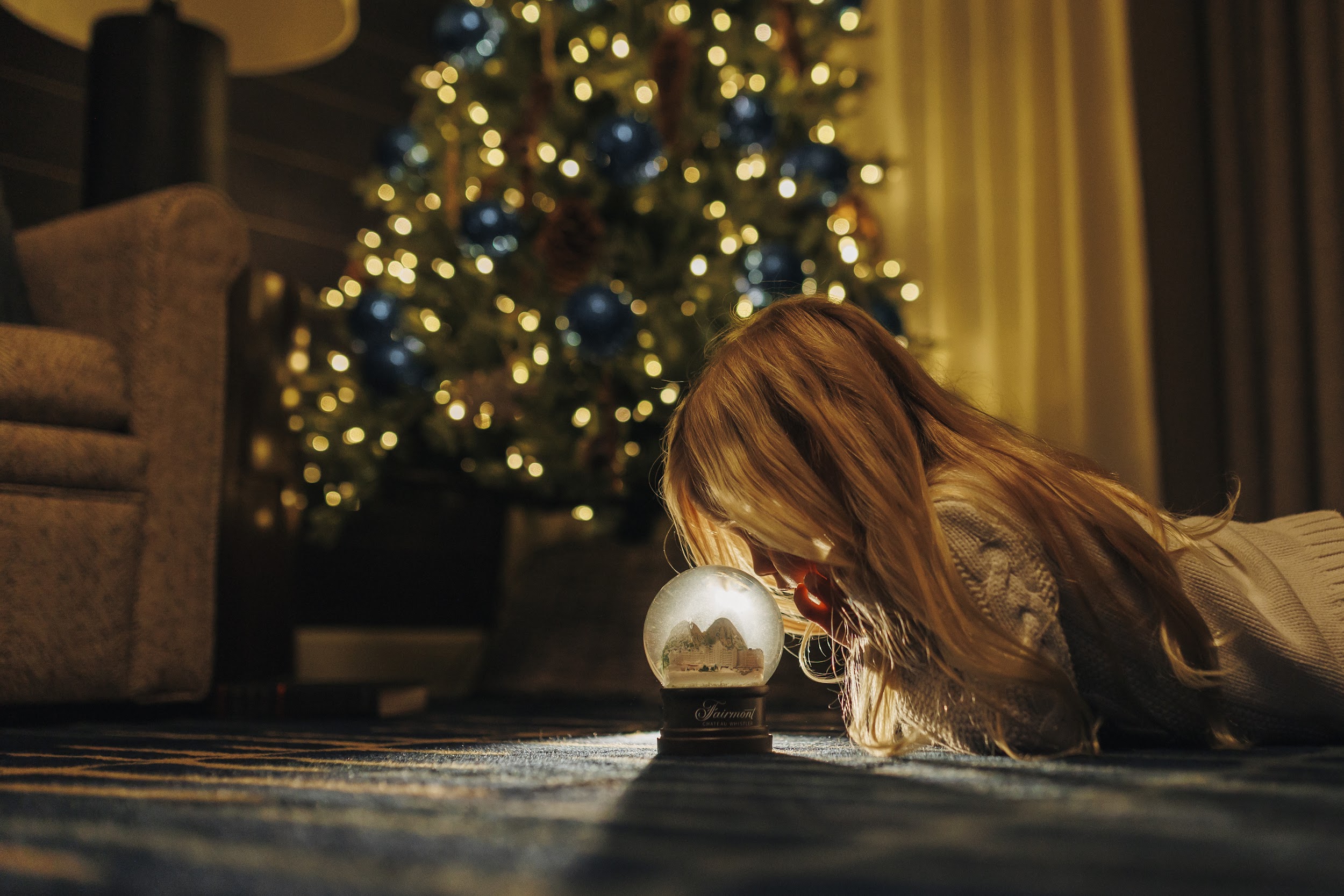 little girl starring at snow globe at fairmont chateau whistler suite