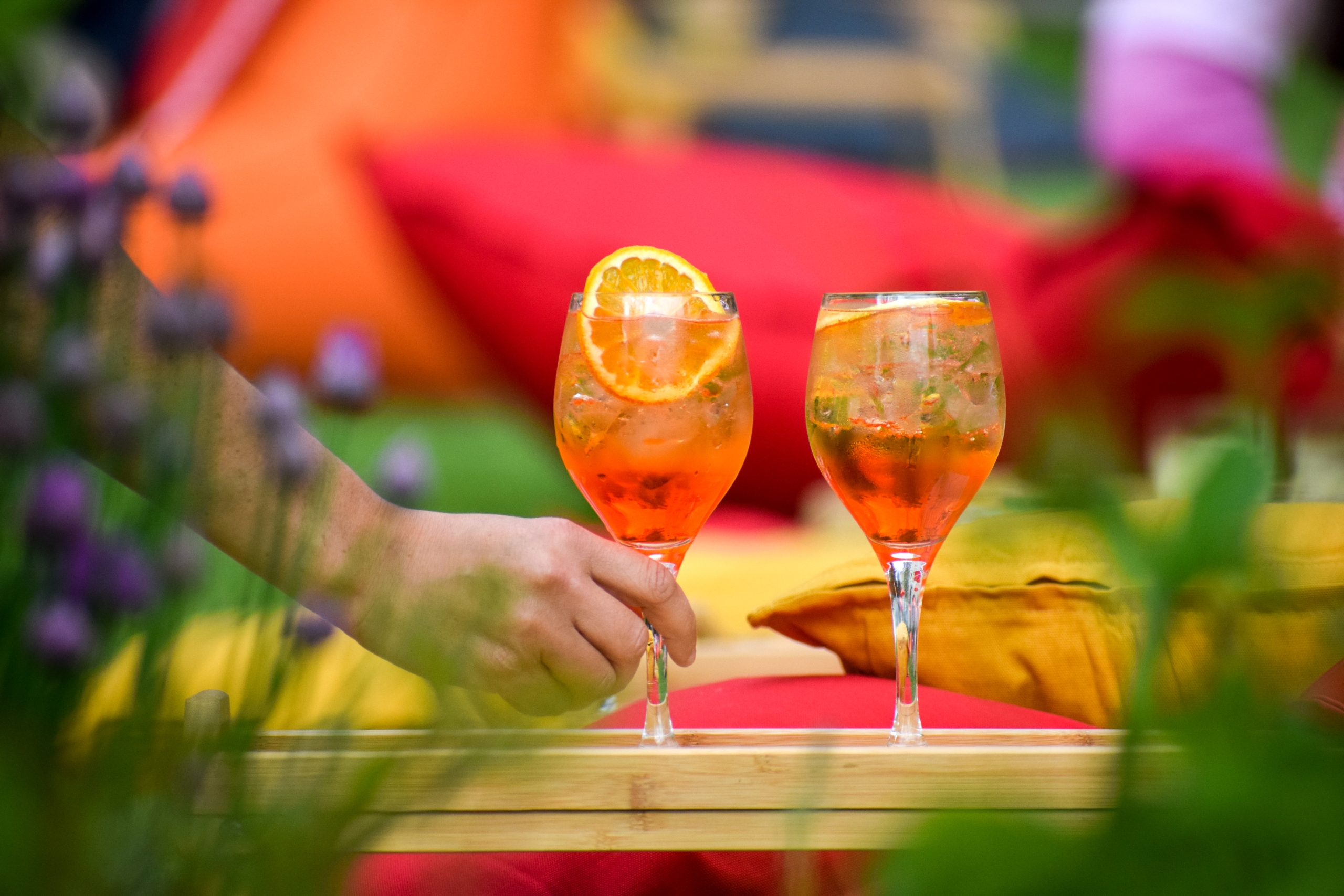 Hand placing an Aperol cocktail on a tray served at Fairmont Fridays Garden Party at the Mallard Lounge