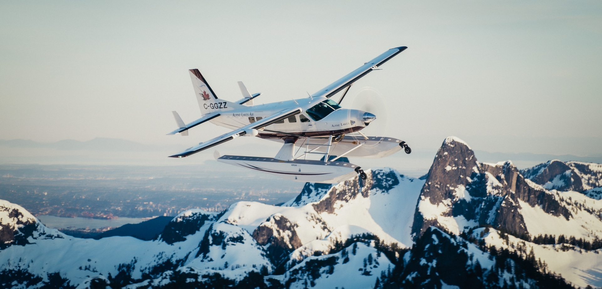 alpine air floatplane flying over whistler snowy peaks