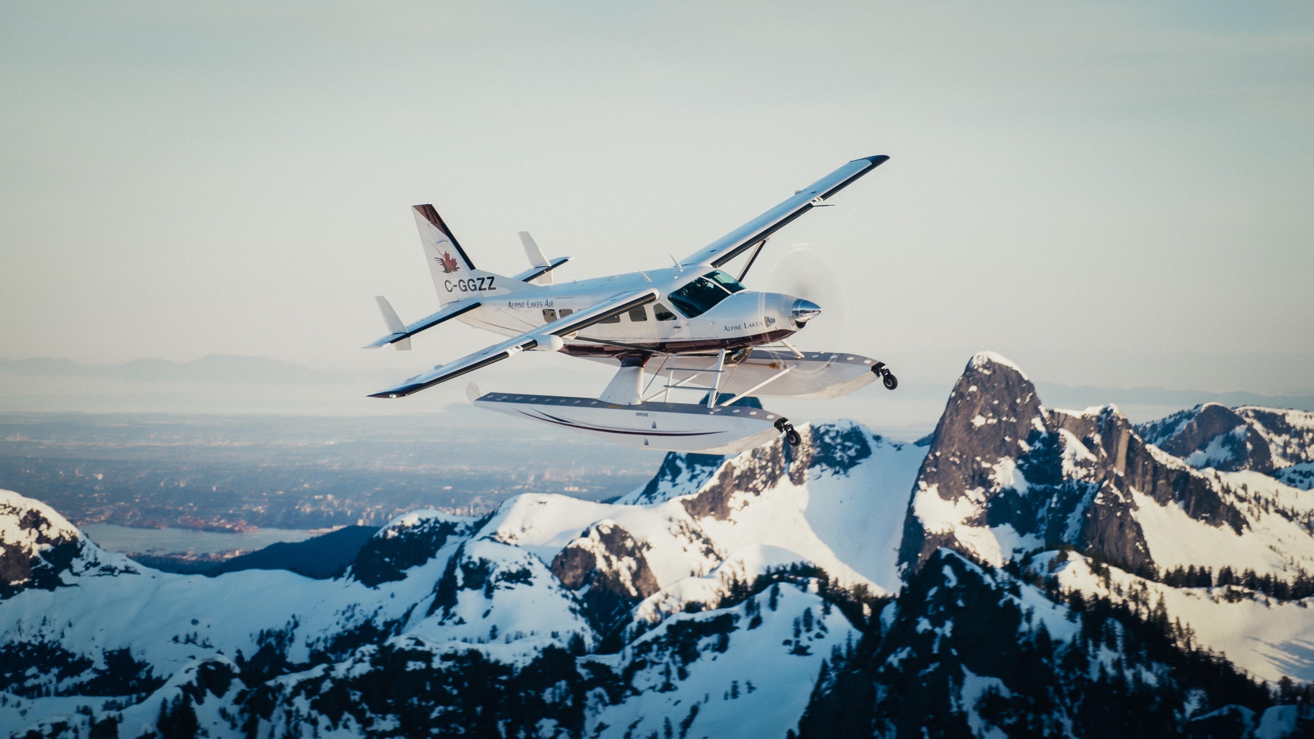 alpine air floatplane flying over whistler snowy peaks