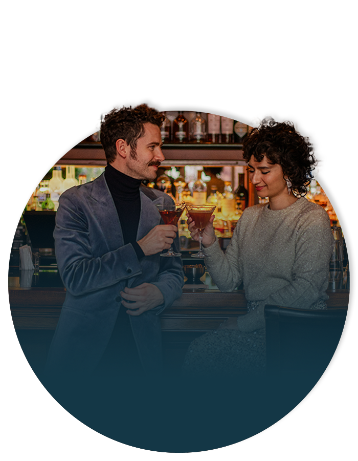 Couple enjoying a festive cocktail at the Mallard Lounge at Fairmont Chateau Whistler