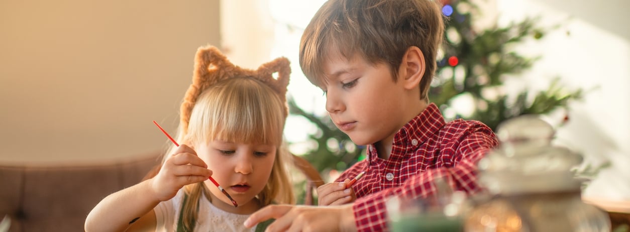 Children paint wooden toys near Christmas tree at Fairmont Chateau Whistler