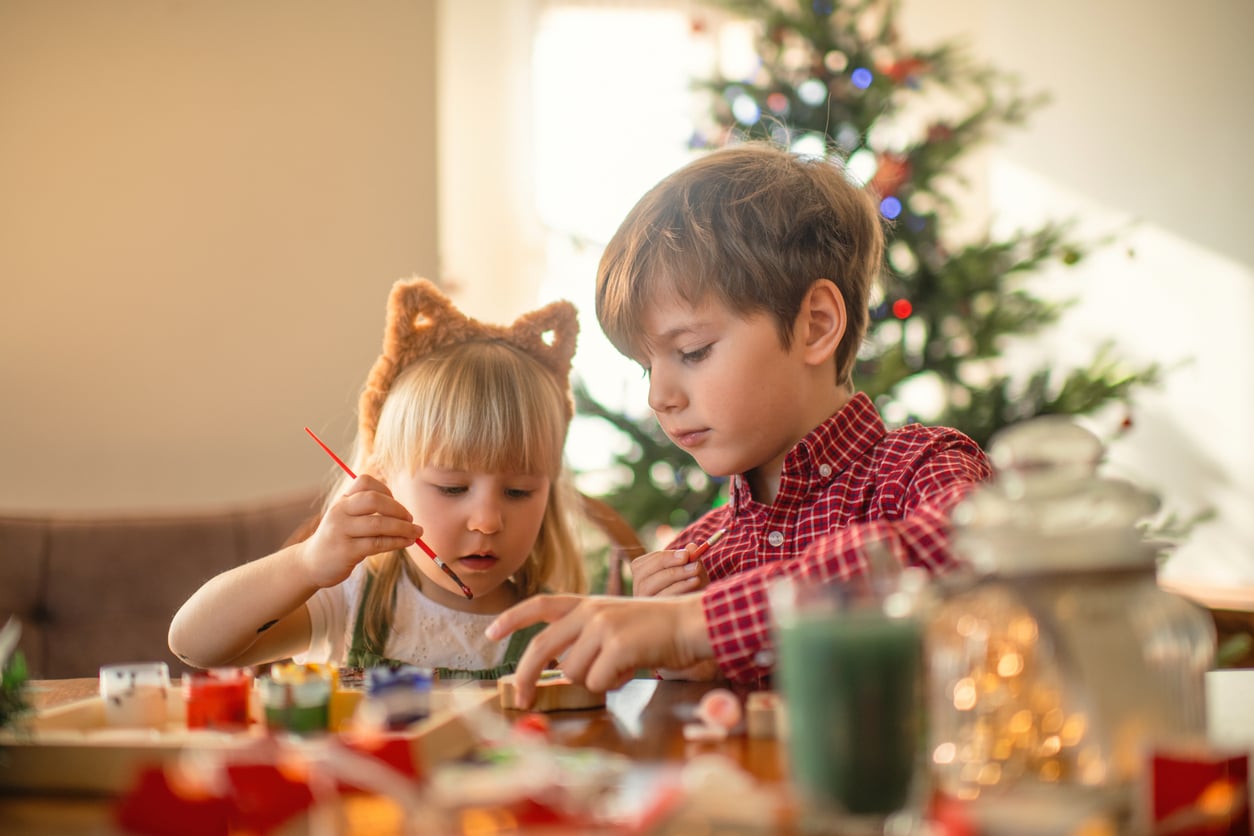 Children paint wooden toys near Christmas tree at Fairmont Chateau Whistler