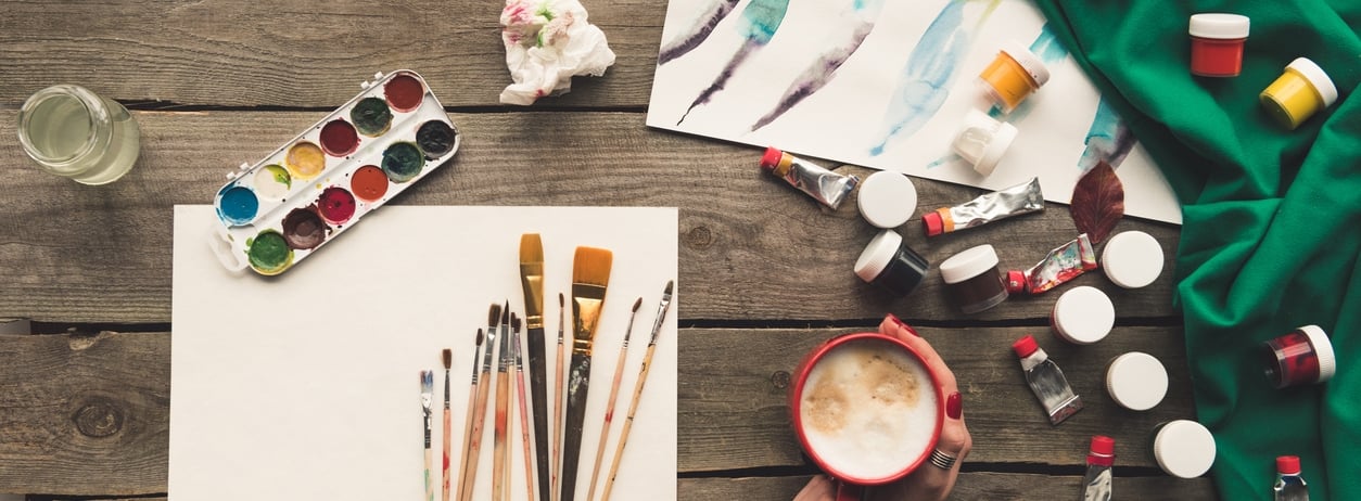 Cropped image of artist drinking coffee at working place