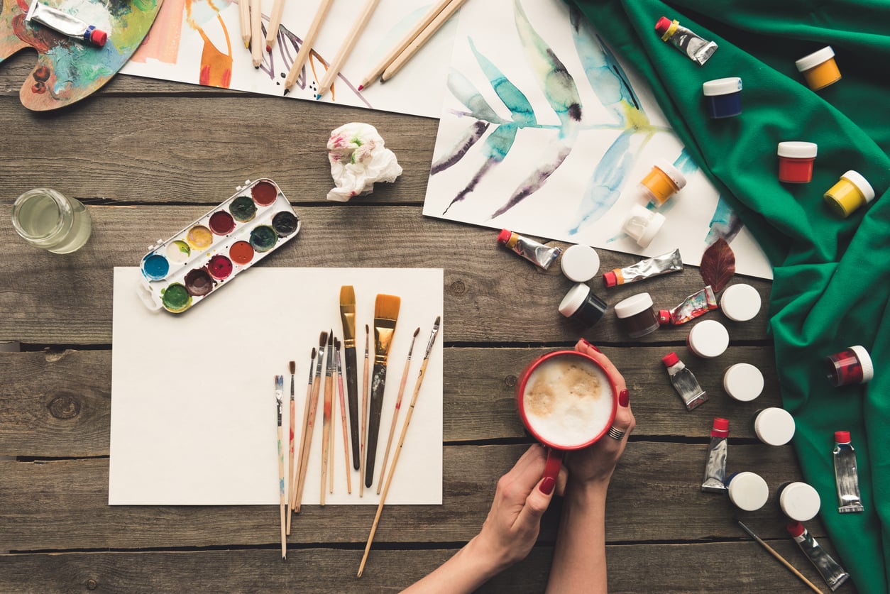 Cropped image of artist drinking coffee at working place